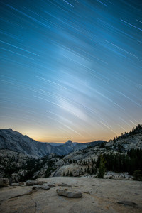 1-hour star trail over Half Dome in the distance at Yosemite National Park