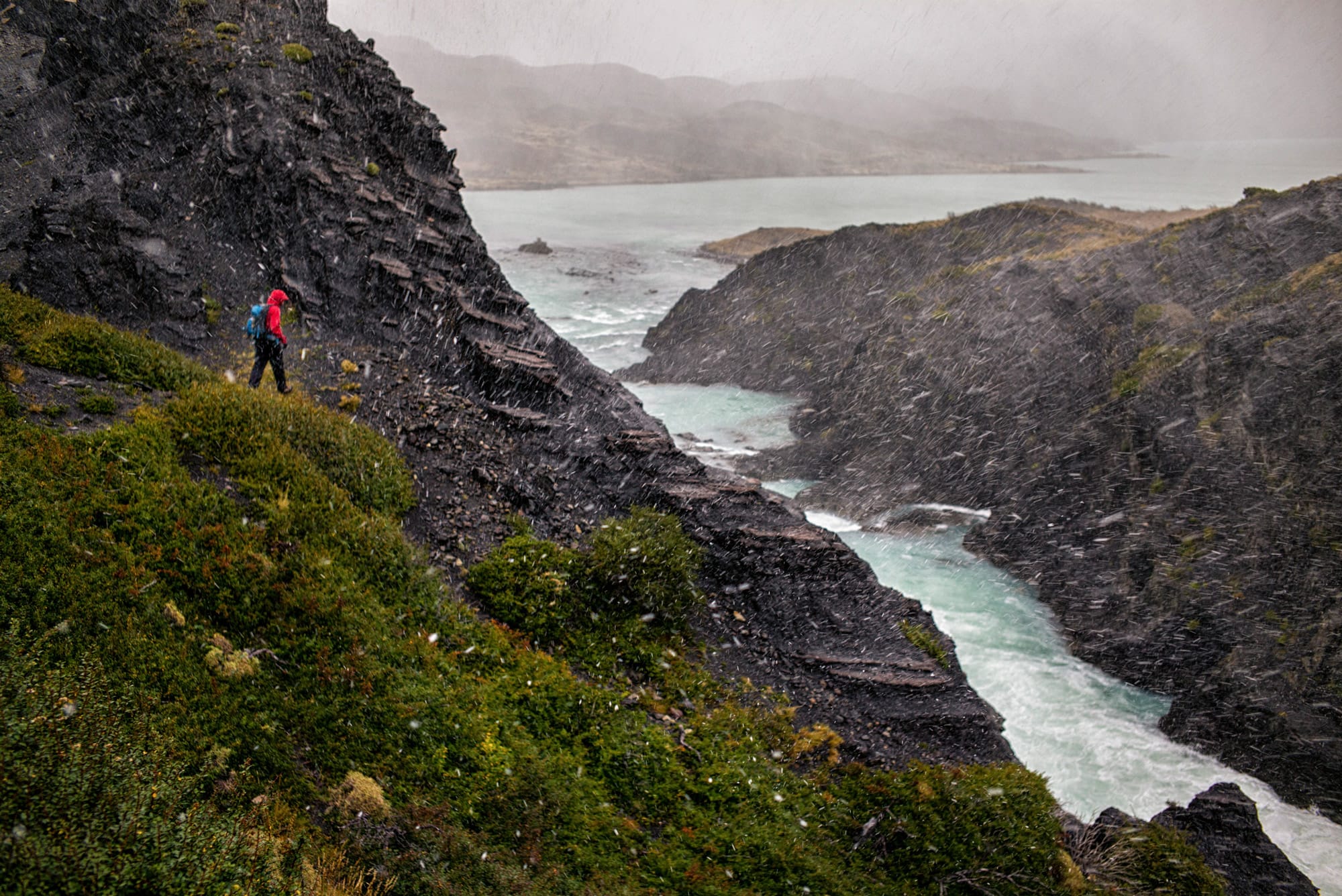 Our fearless guide Javier surveying the waterfall from a cliff side in the snow and wind.