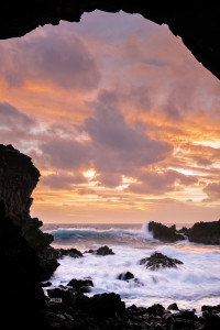 Wave crashing on rocks during a sunset on Easter Island
