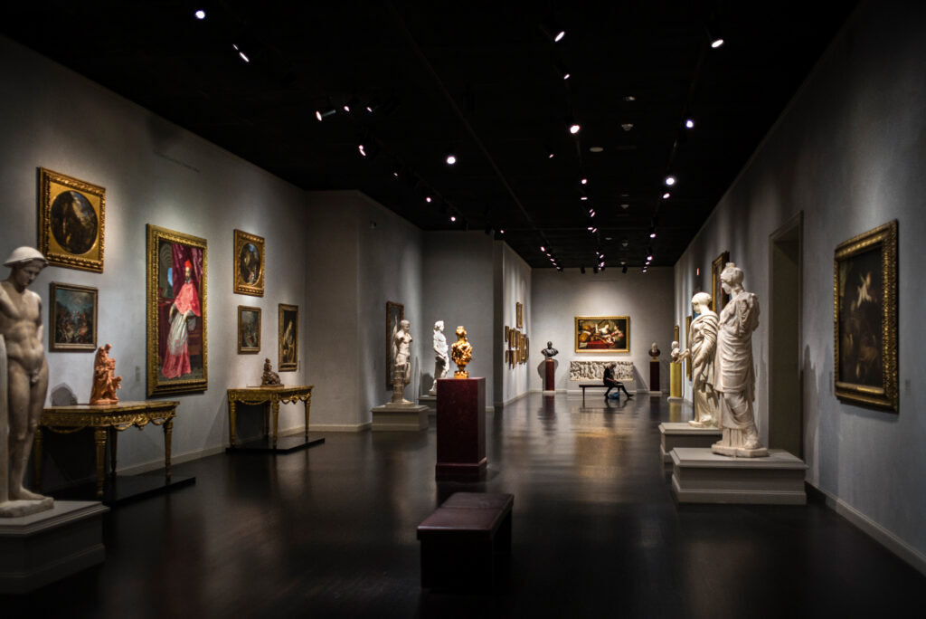 Statues seemingly stare at a woman drawing their stony forms