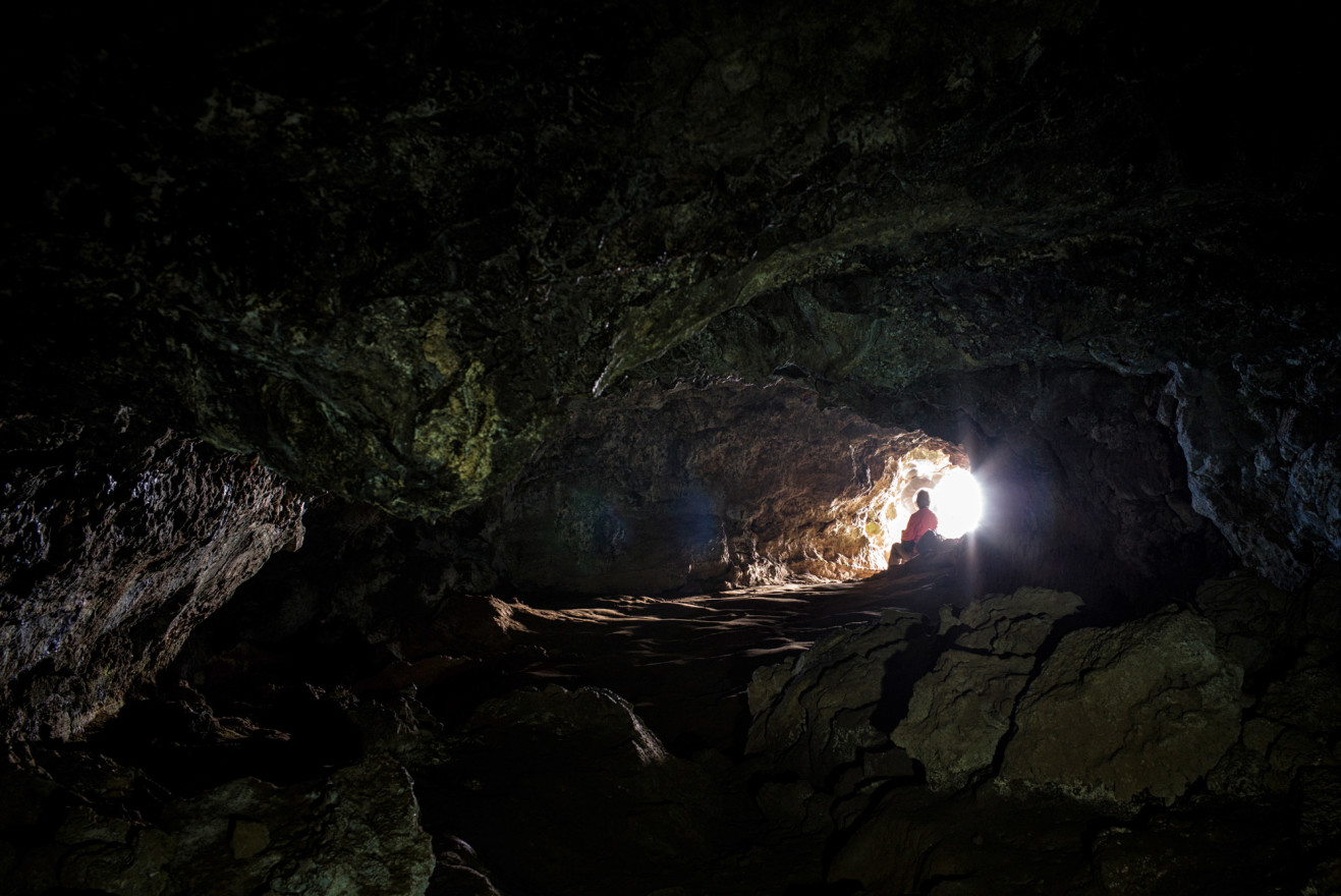 A workshop participant taking in the ocean view from the mouth of a cave